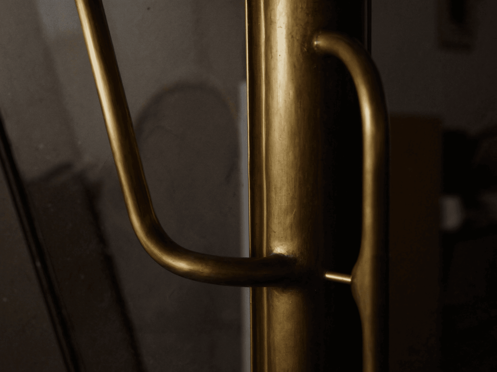 Détail laiton fait main fonderie Bois-d'Arcy 50 km atelier Bruyères — main courante + porte battante