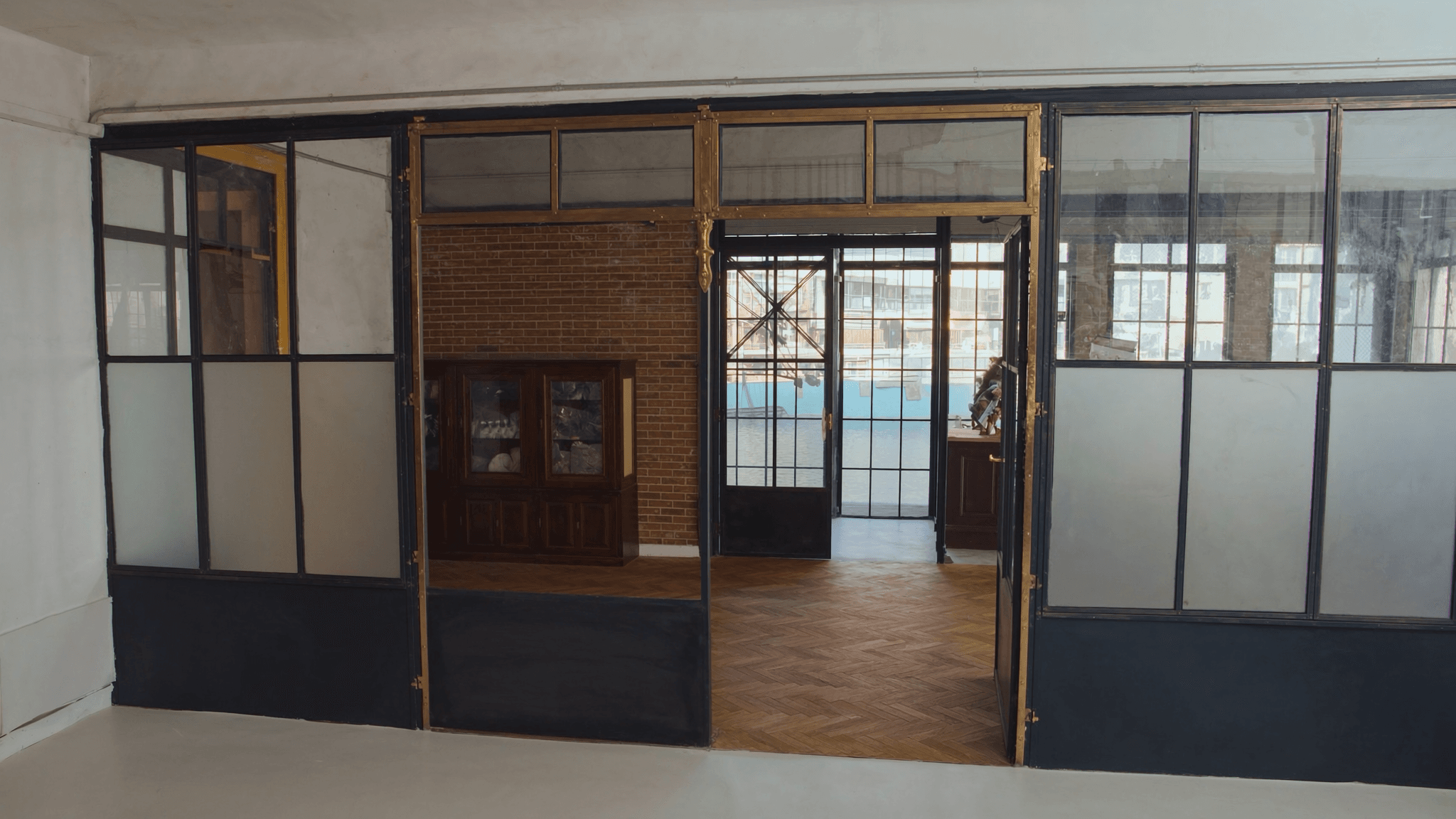 Verrière atelier loft reconverti Paris 10e Canal Saint-Martin — profil acier S235JR T 40 × 40 mm patine bronze antique sur mesure par Yann + laiton fait main fonderie Bois-d'Arcy 36 km + verre Saint-Gobain Diamant 8+8 mm — proximité Canal Saint-Martin classé MH 1993